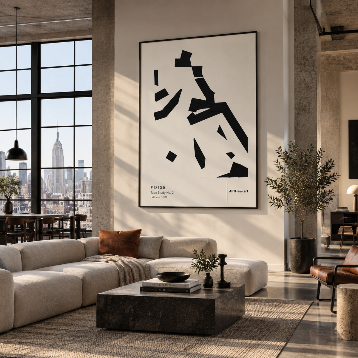 A large framed abstract black and white art print hangs on a wall in a modern loft living room